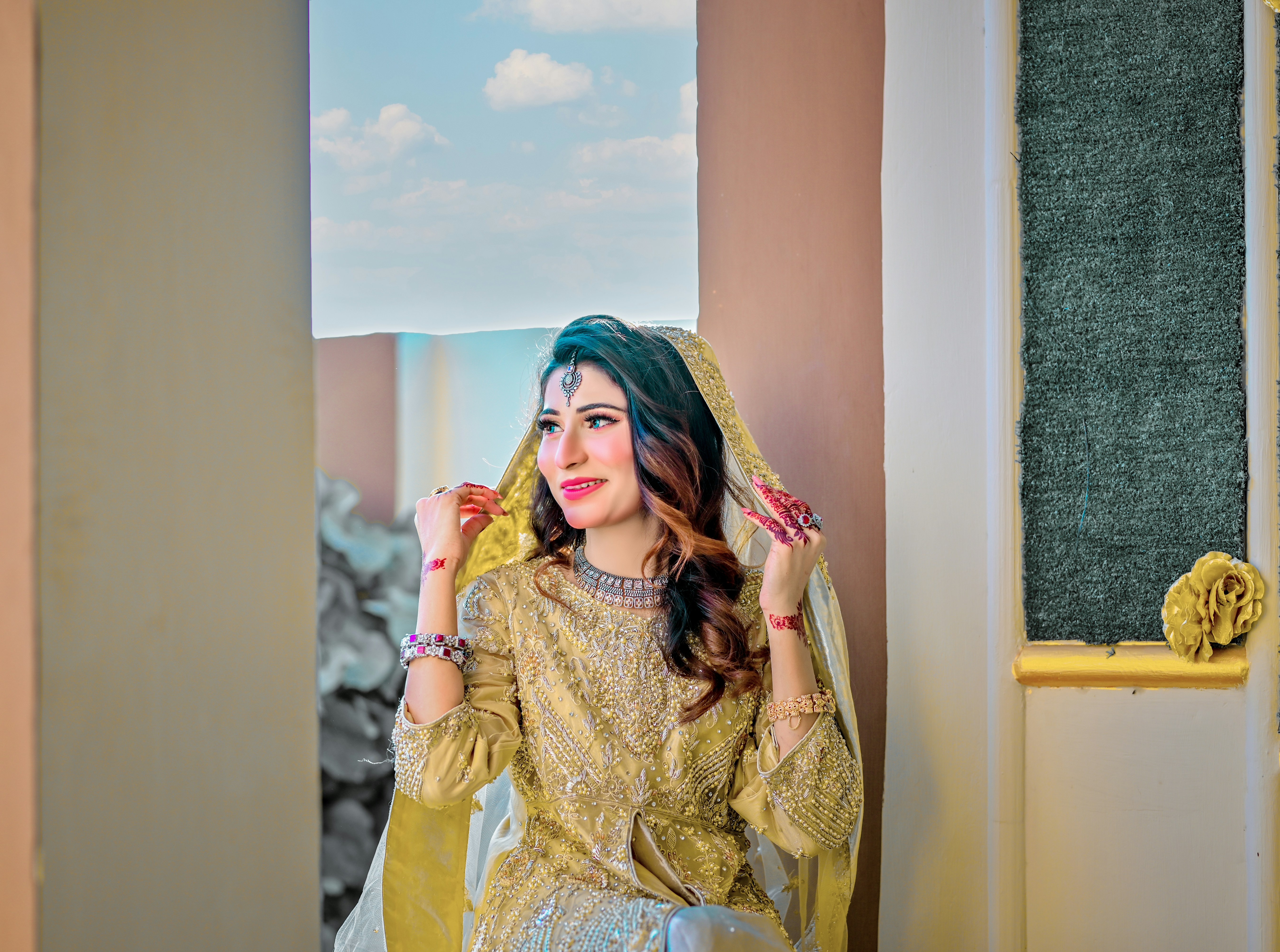 A woman in a yellow outfit standing in front of a window
