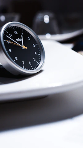 A clock sitting on top of a white plate