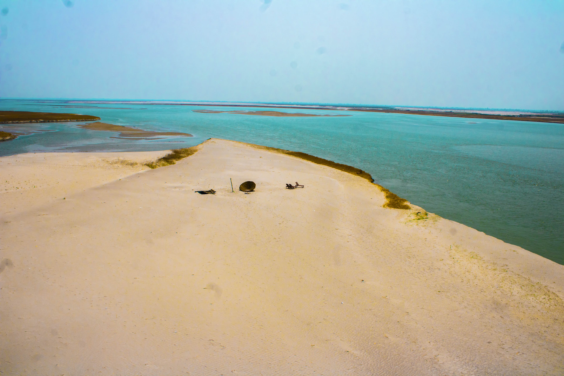 A view of a sandy beach with a body of water in the background