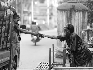 A black and white photo of a man shaking another man's hand