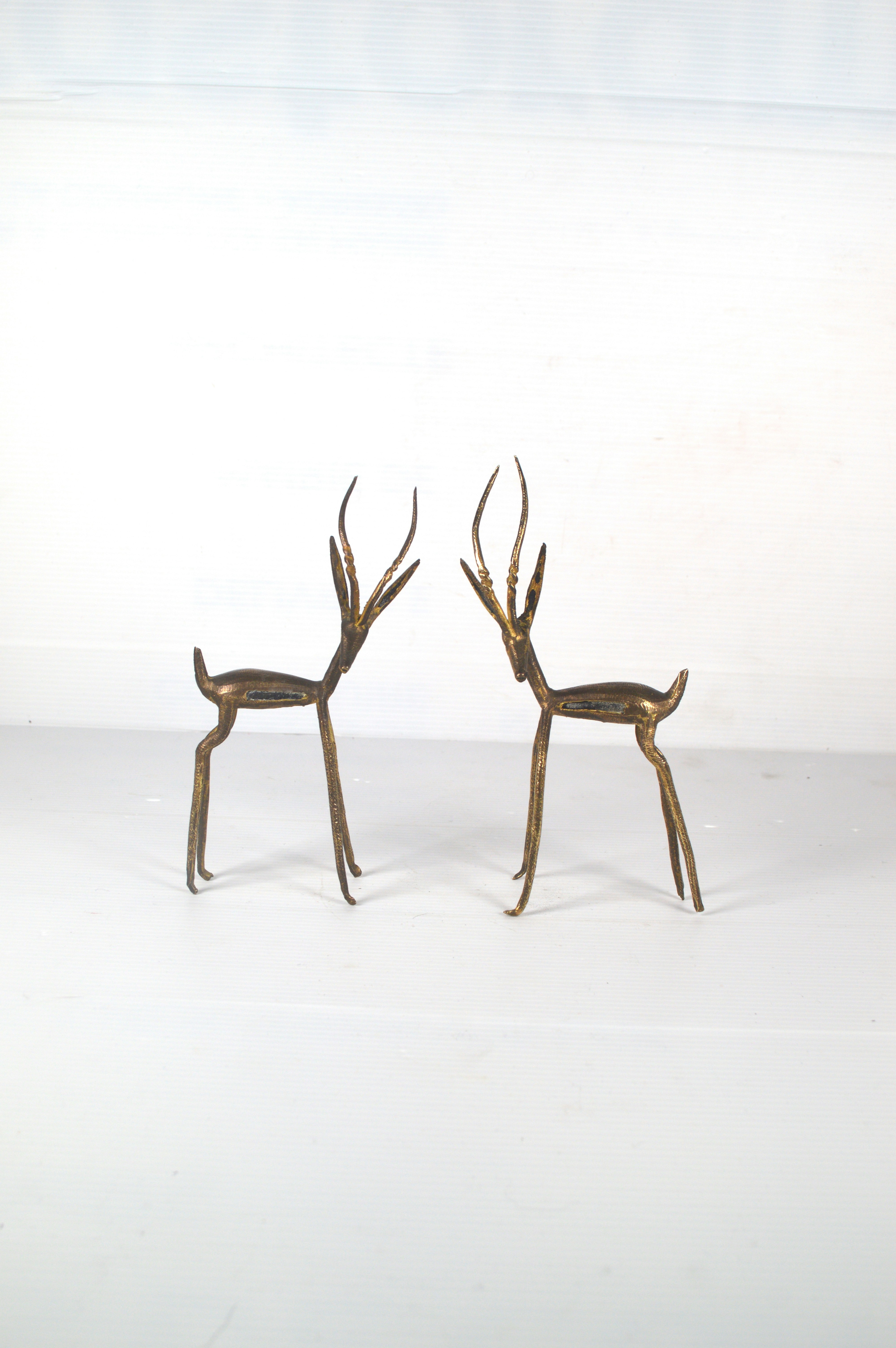 un paio di statue di cervo in piedi uno accanto all'altro