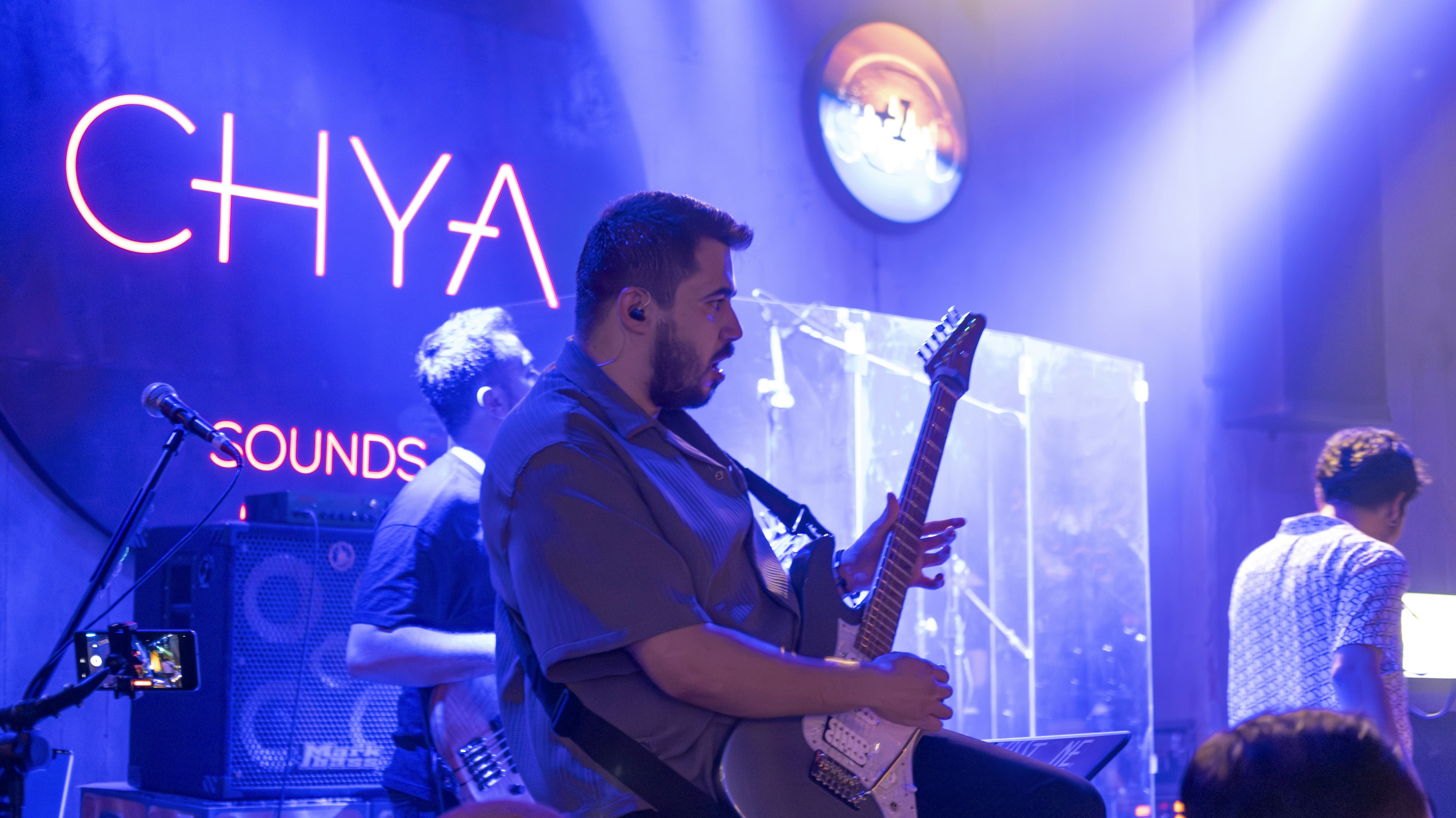 A man sitting on a stool playing a guitar