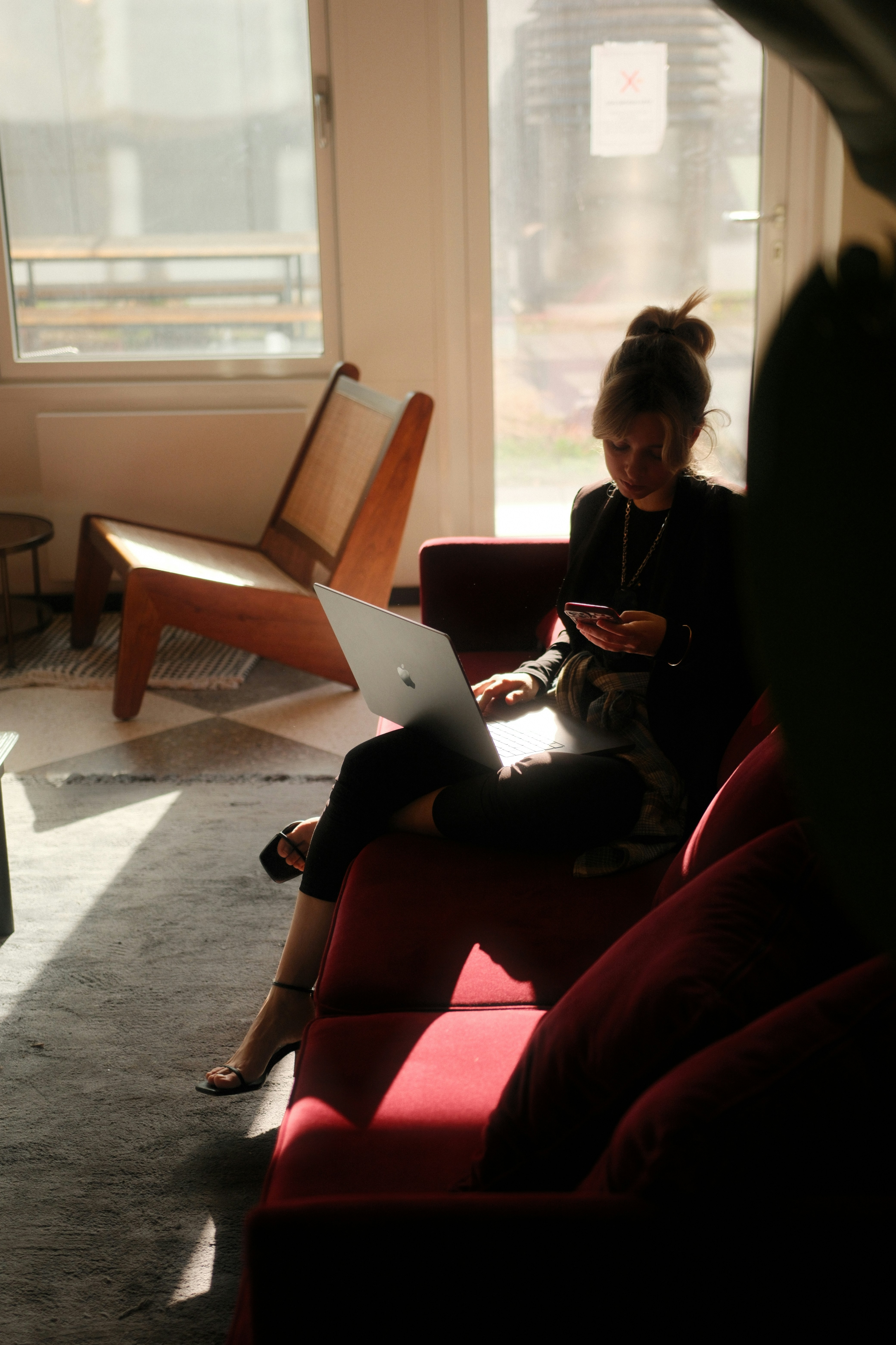 A woman sitting on a couch using a laptop computer