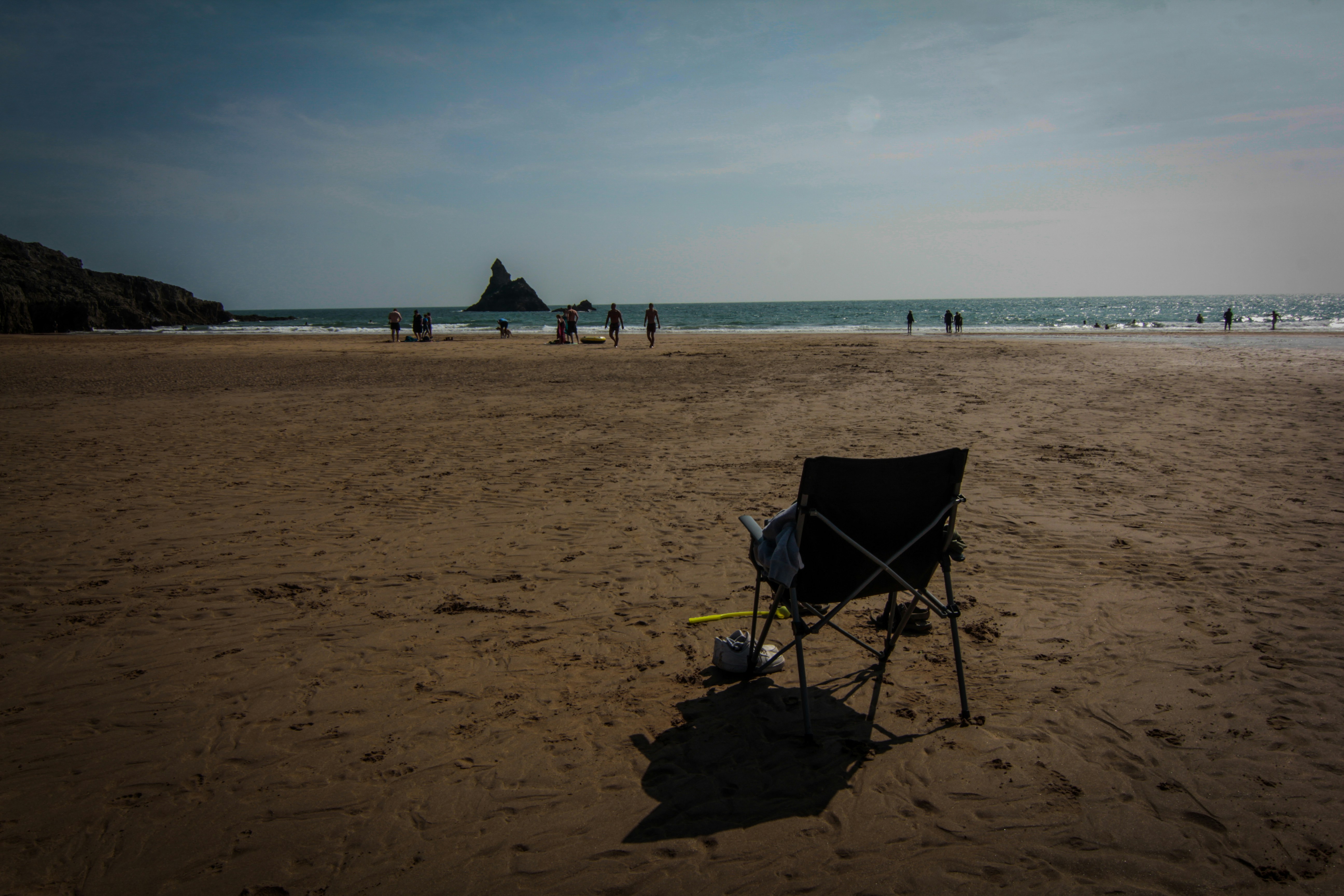 Una silla sentada en la cima de una playa de arena