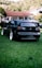 A black car parked on top of a lush green field