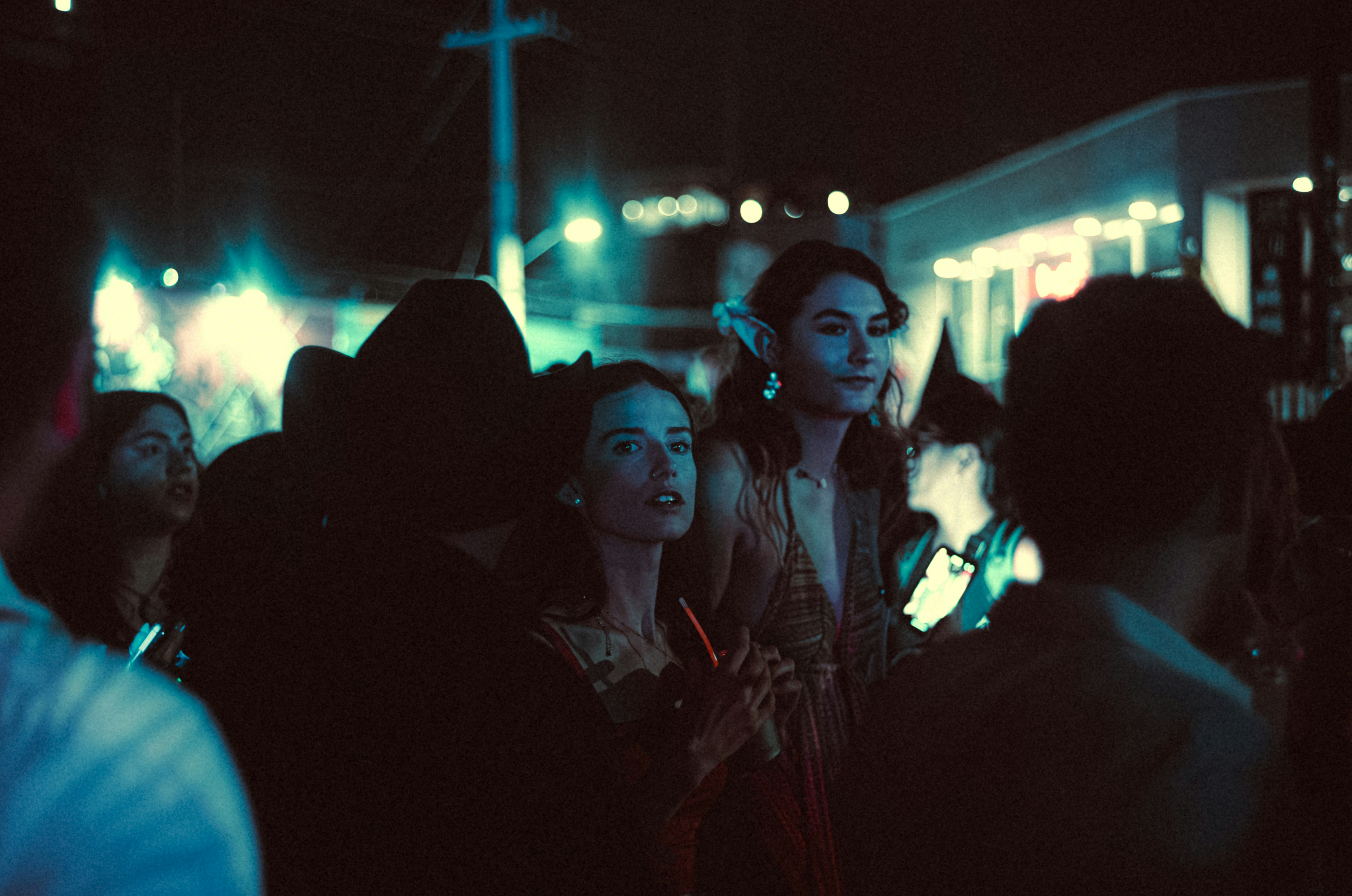 A group of people standing around a train station at night