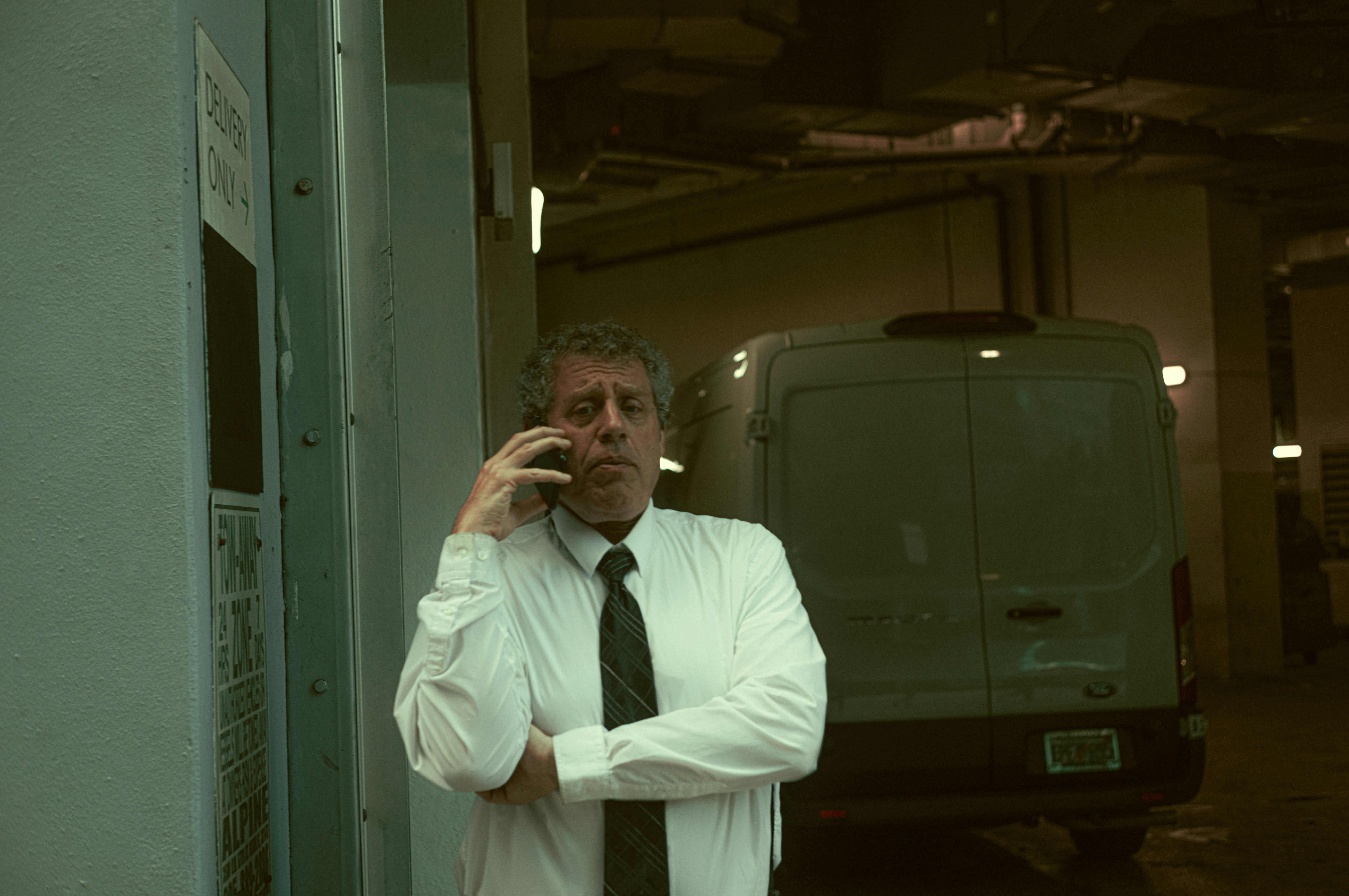 A man in a white shirt and tie talking on a cell phone