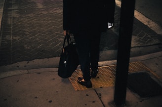 A woman standing on a sidewalk at night