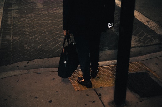 A woman standing on a sidewalk at night