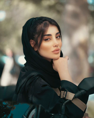 A woman in a black hijab sitting on a car