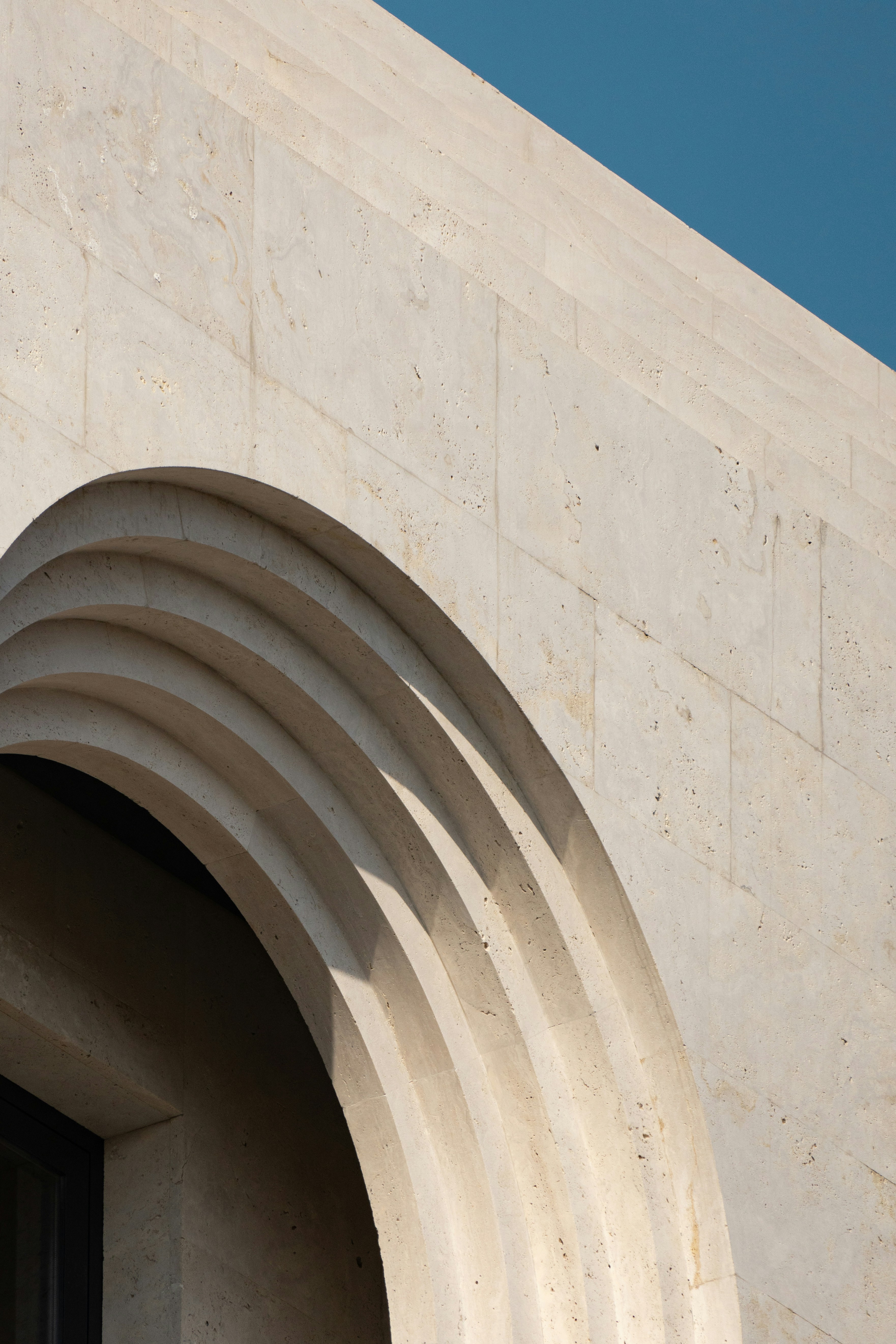 A clock on the side of a building with a blue sky in the background