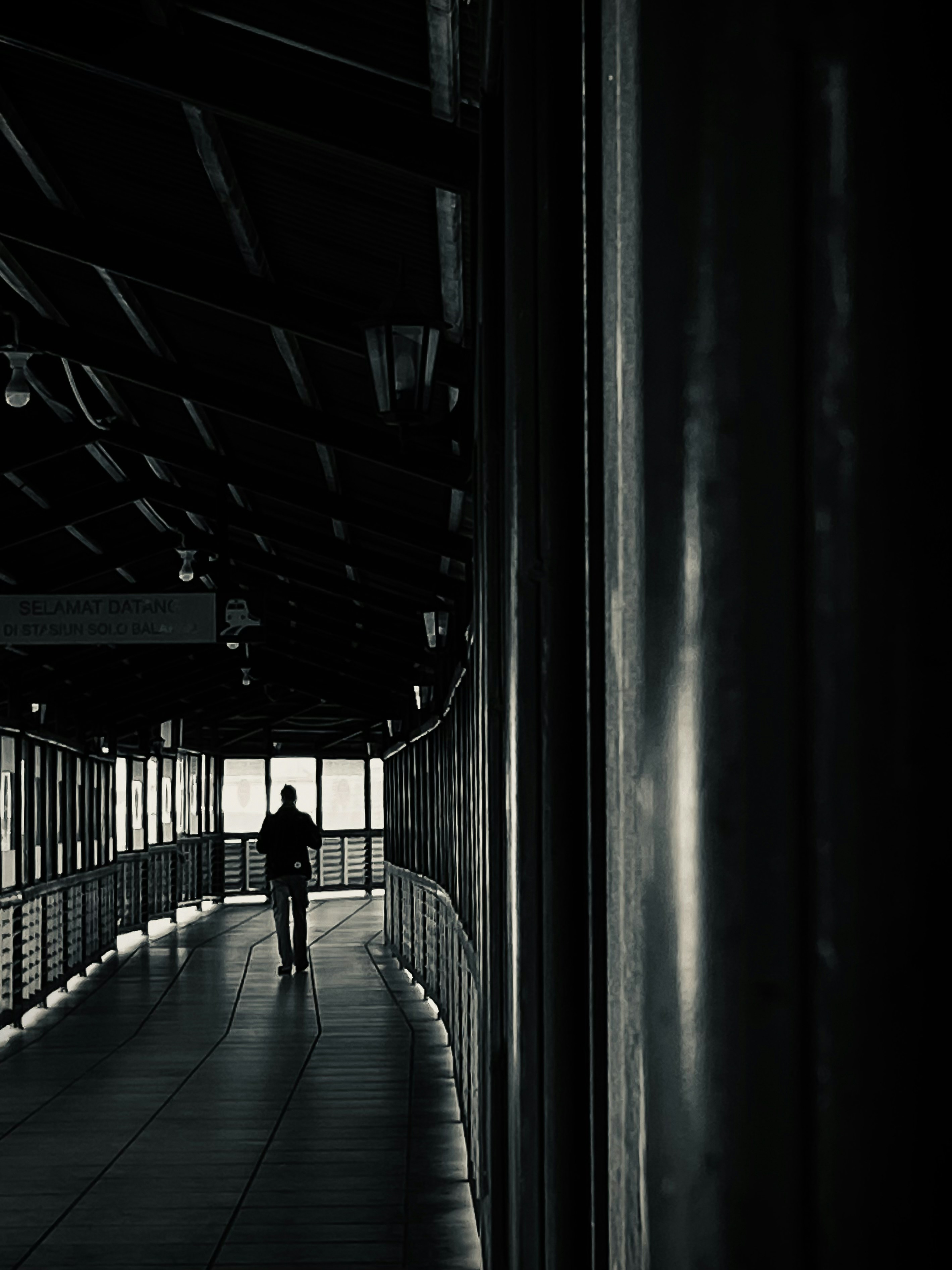 A person walking down a walkway in a building