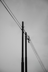 A black and white photo of power lines and telephone poles
