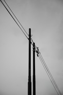 A black and white photo of power lines and telephone poles