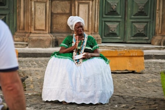 A woman in a green and white dress sitting on a bench