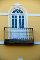 A balcony with a wrought iron railing and a window