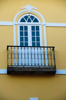 A balcony with a wrought iron railing and a window