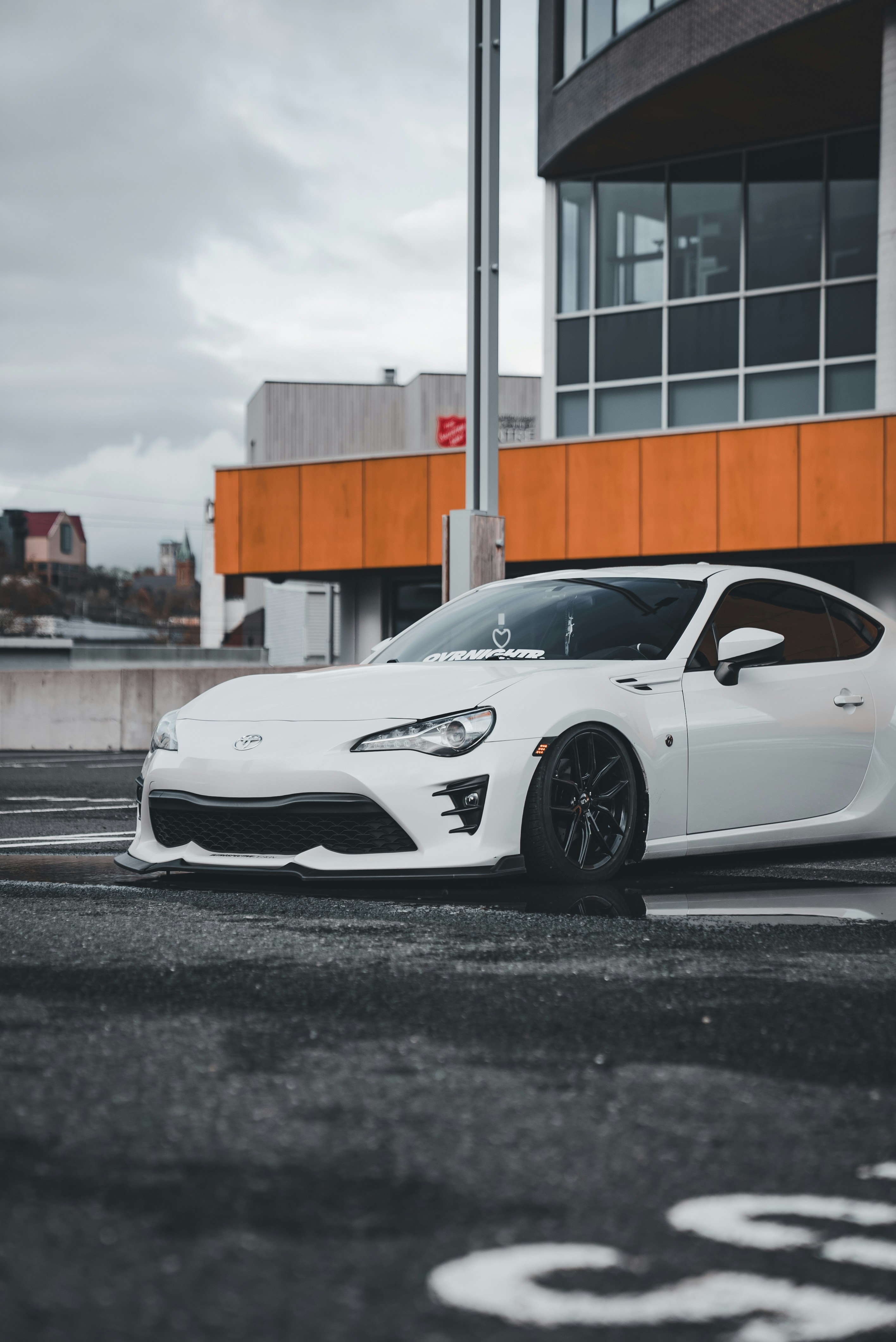 Ein weißer Sportwagen, der vor einem Gebäude parkt