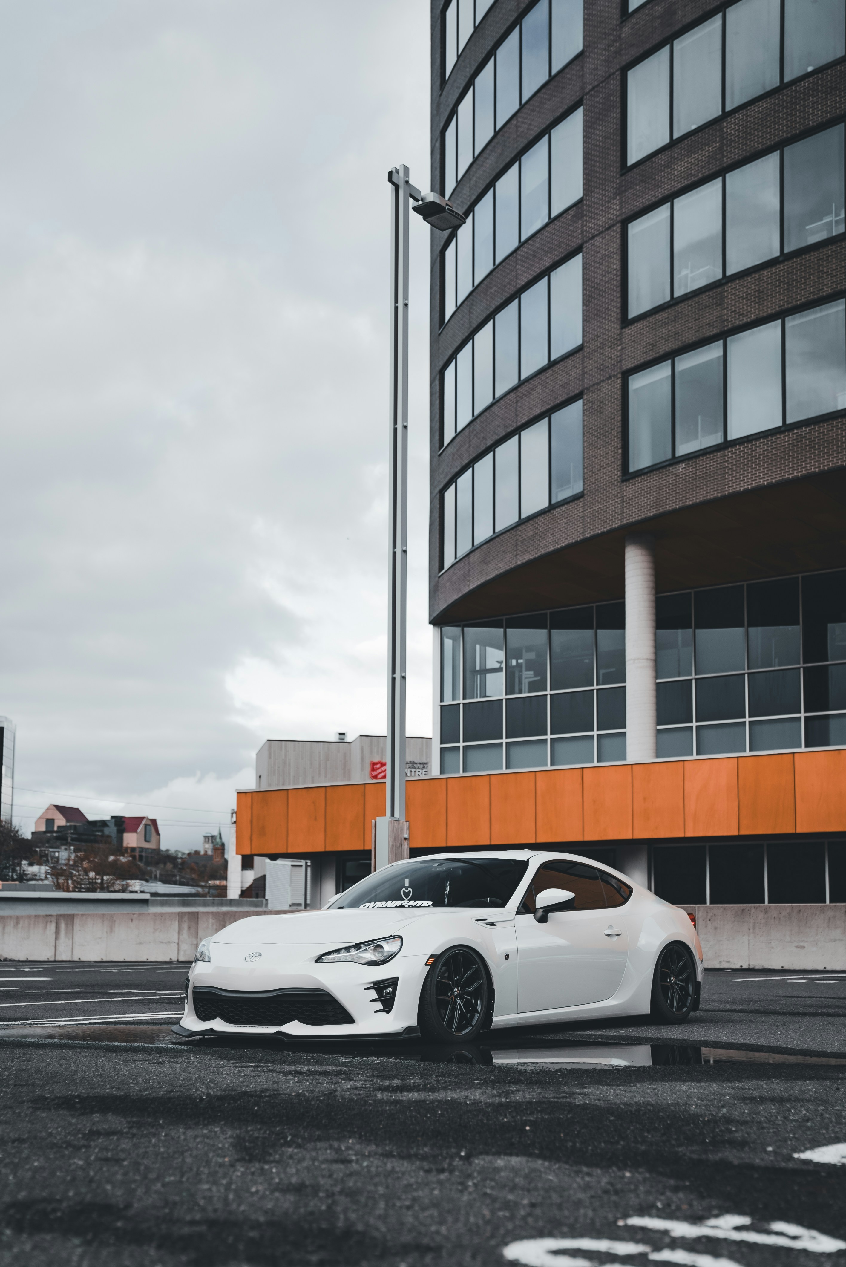 Ein weißer Sportwagen, der vor einem Gebäude parkt