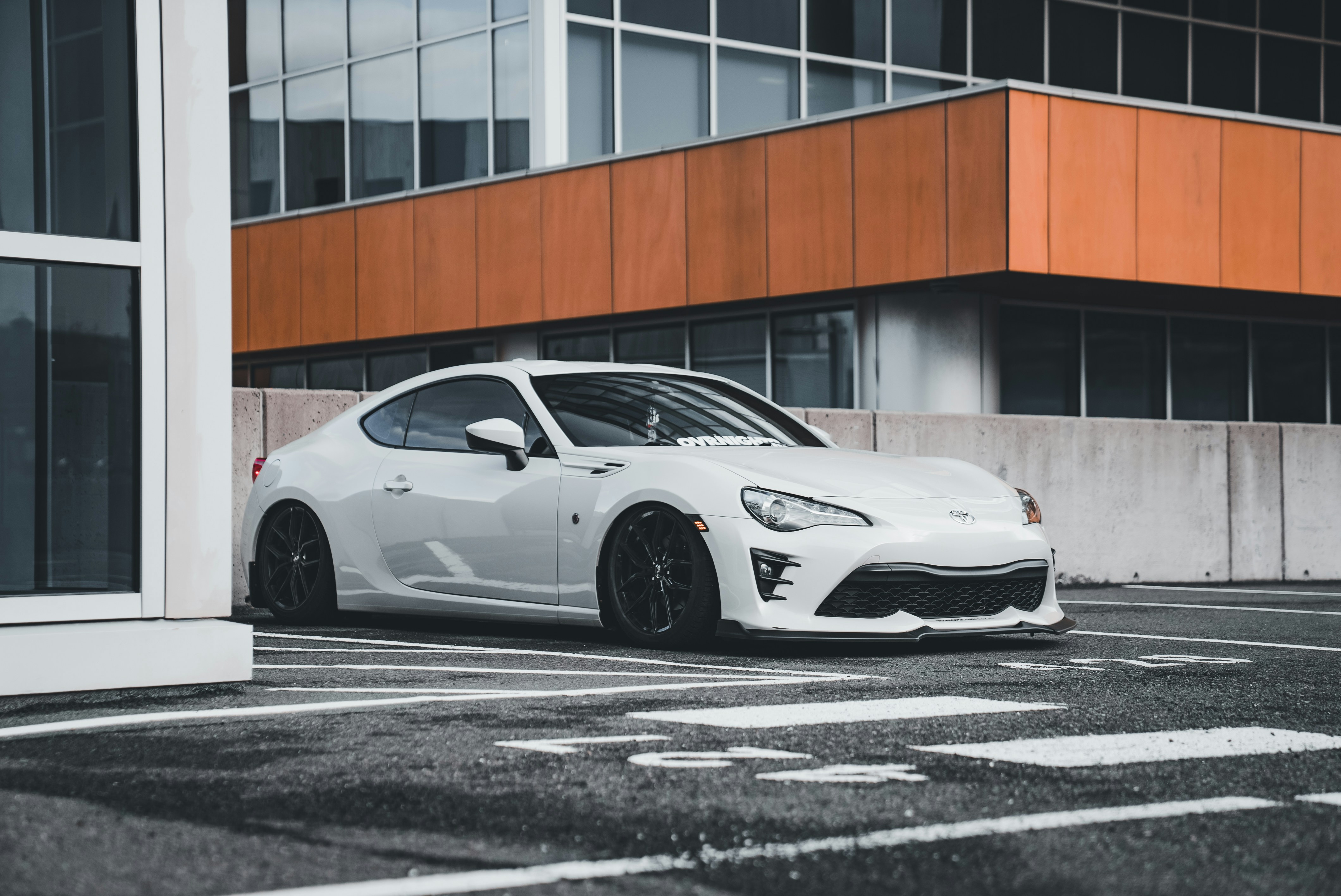 Ein weißer Sportwagen, der vor einem Gebäude parkt
