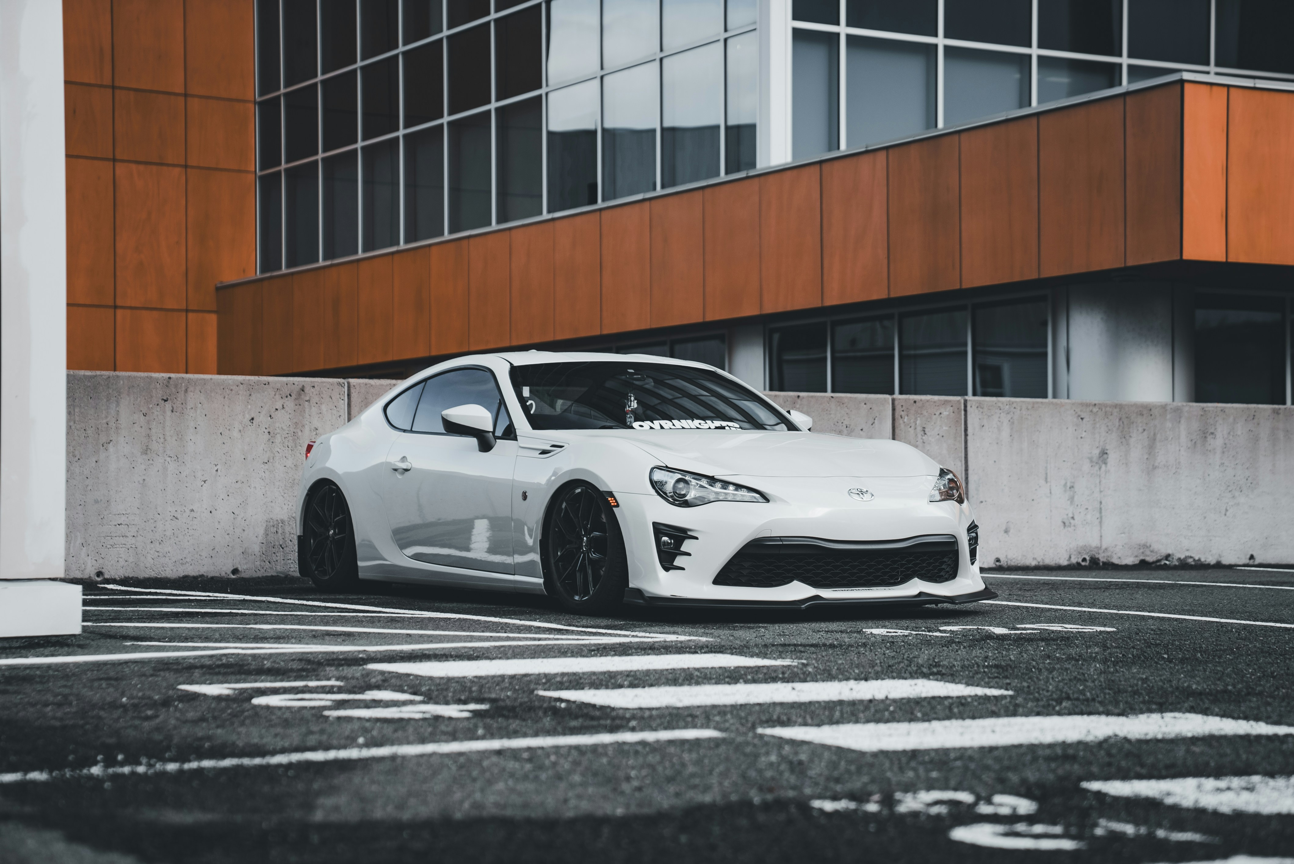 Ein weißer Sportwagen, der vor einem Gebäude parkt