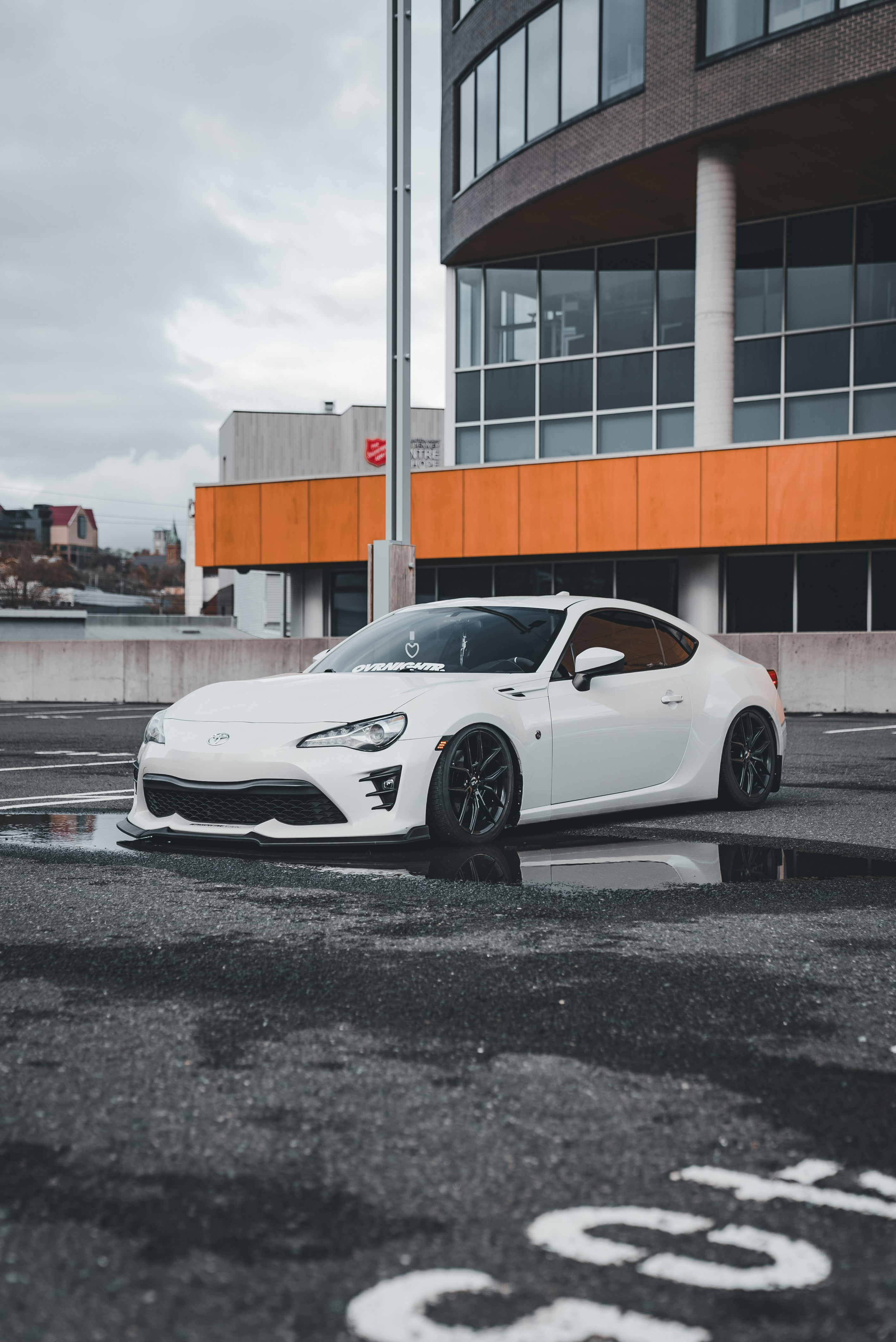 Ein weißer Sportwagen, der vor einem Gebäude parkt