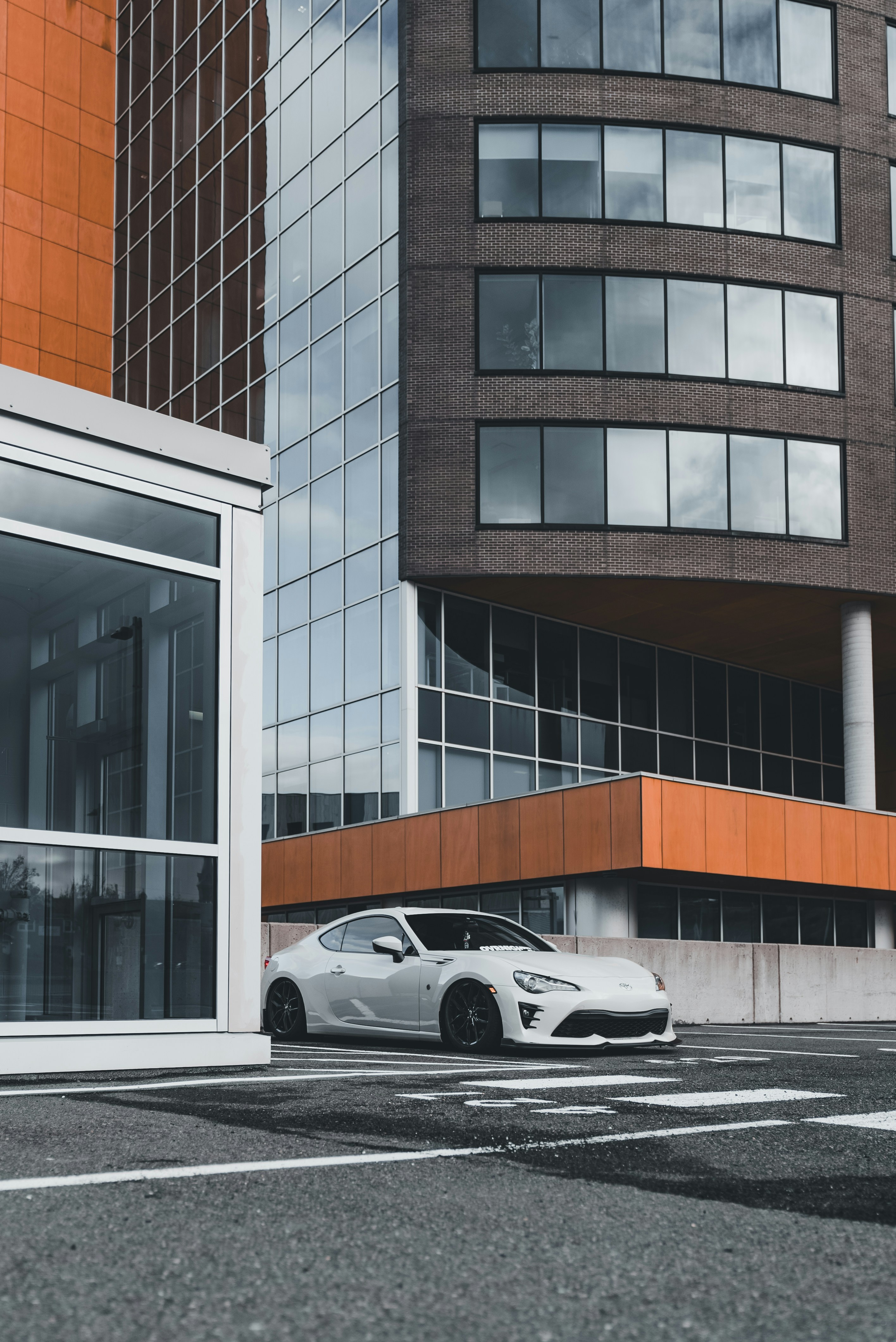 Ein weißes Auto, das vor einem hohen Gebäude geparkt ist