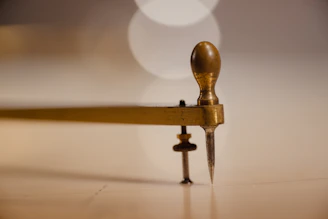 A small wooden object with a long handle