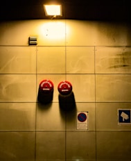 A couple of parking meters mounted to the side of a wall