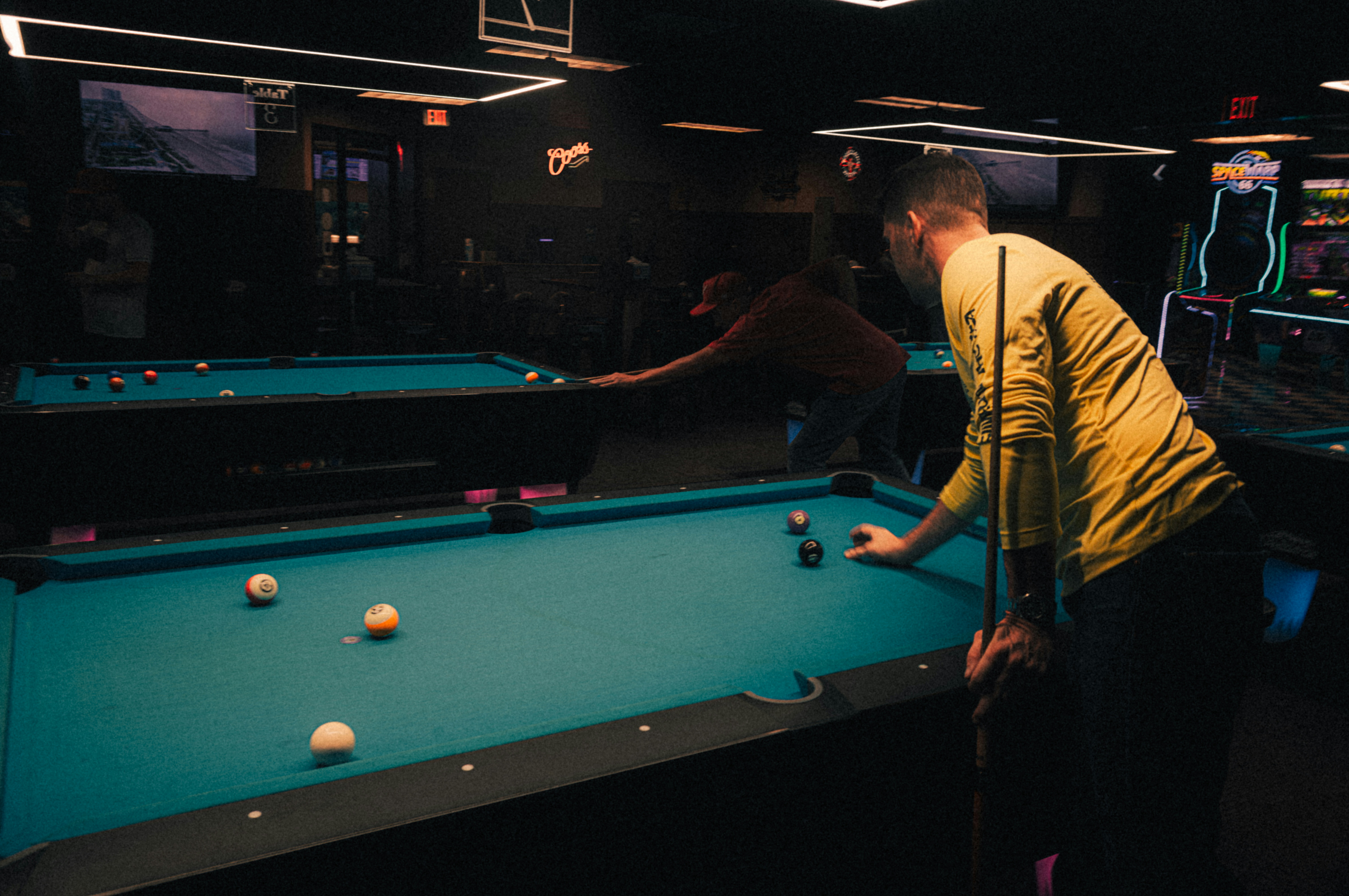 Zwei Männer spielen Billard in einem dunklen Raum