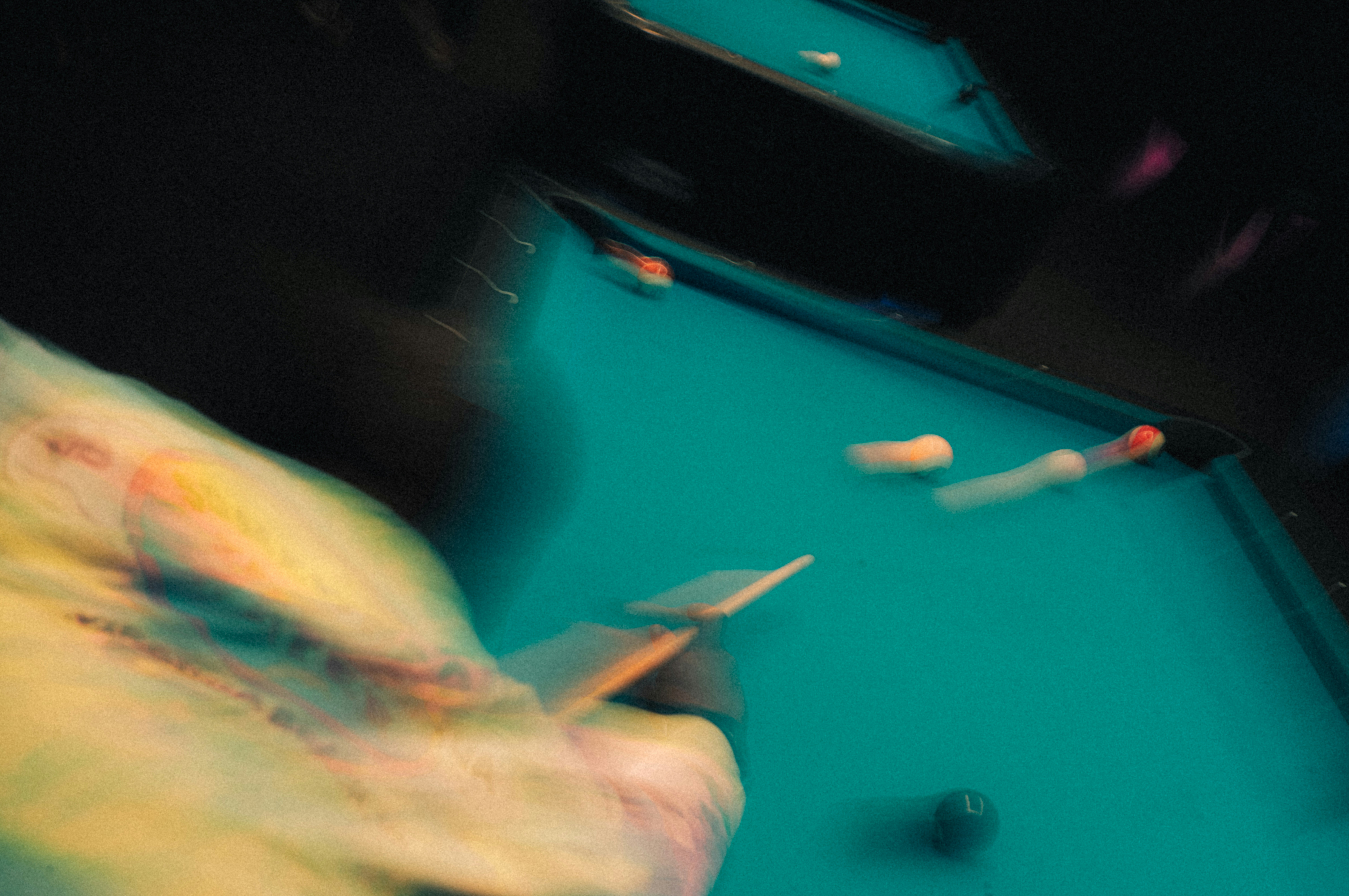 A blurry photo of a person playing pool