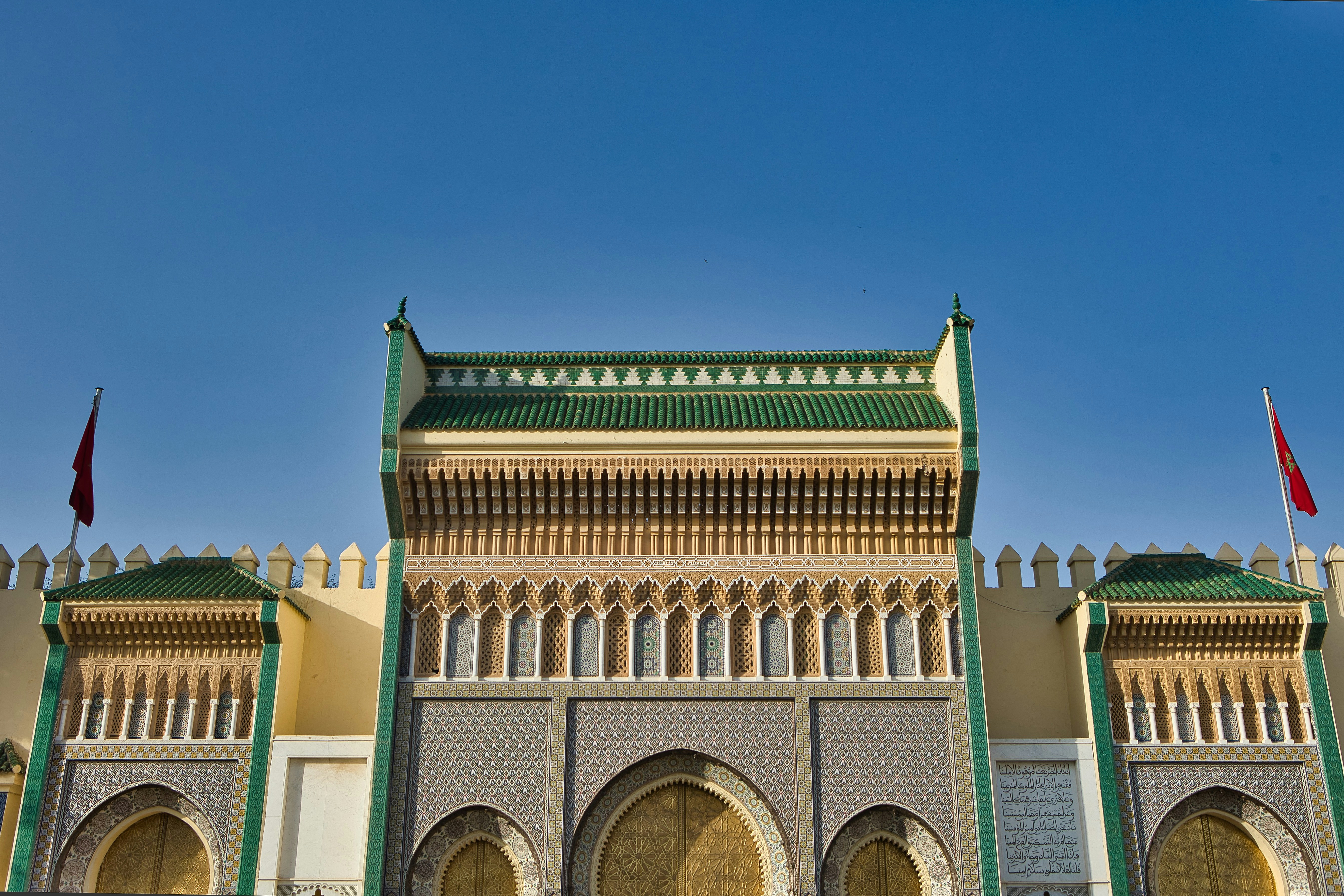 A large building with a lot of arches and flags on top of it