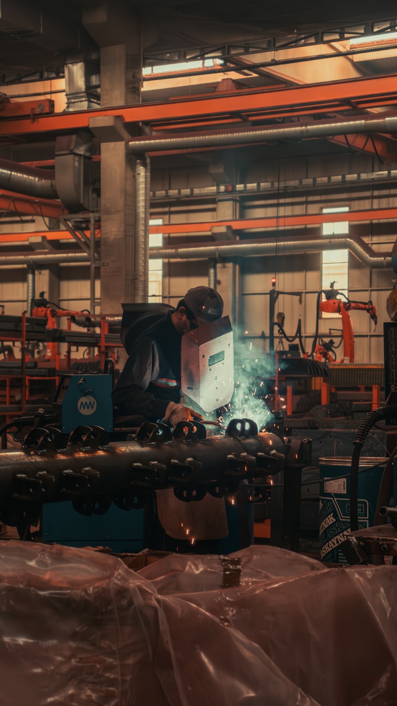 Steel factory with welders and industrial manufacturing equipment