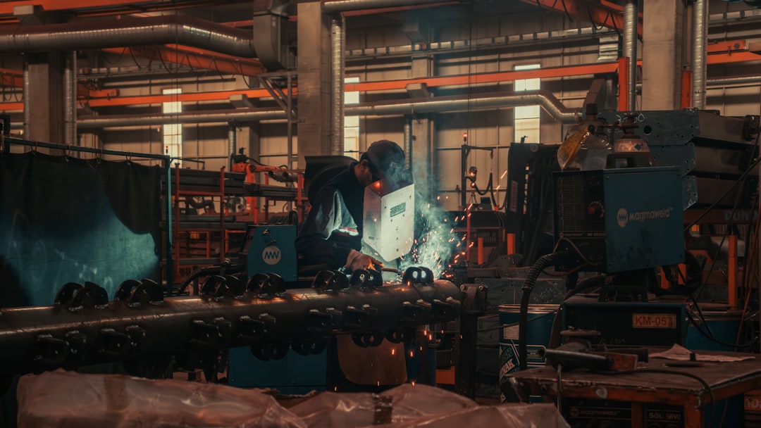 A man working on a machine in a factory, a factory worker welding
