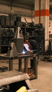 A man working on a piece of equipment in a factory