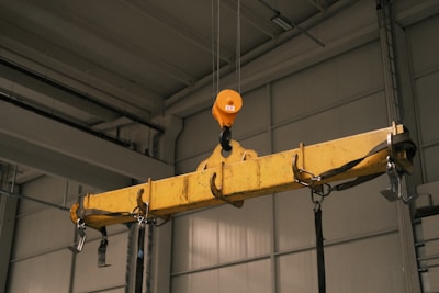 A yellow crane hanging from a ceiling in a garage