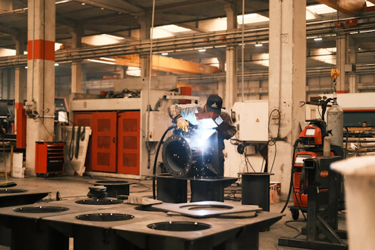 A man welding a piece of metal in a factory
