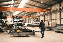 A man is walking through a large warehouse