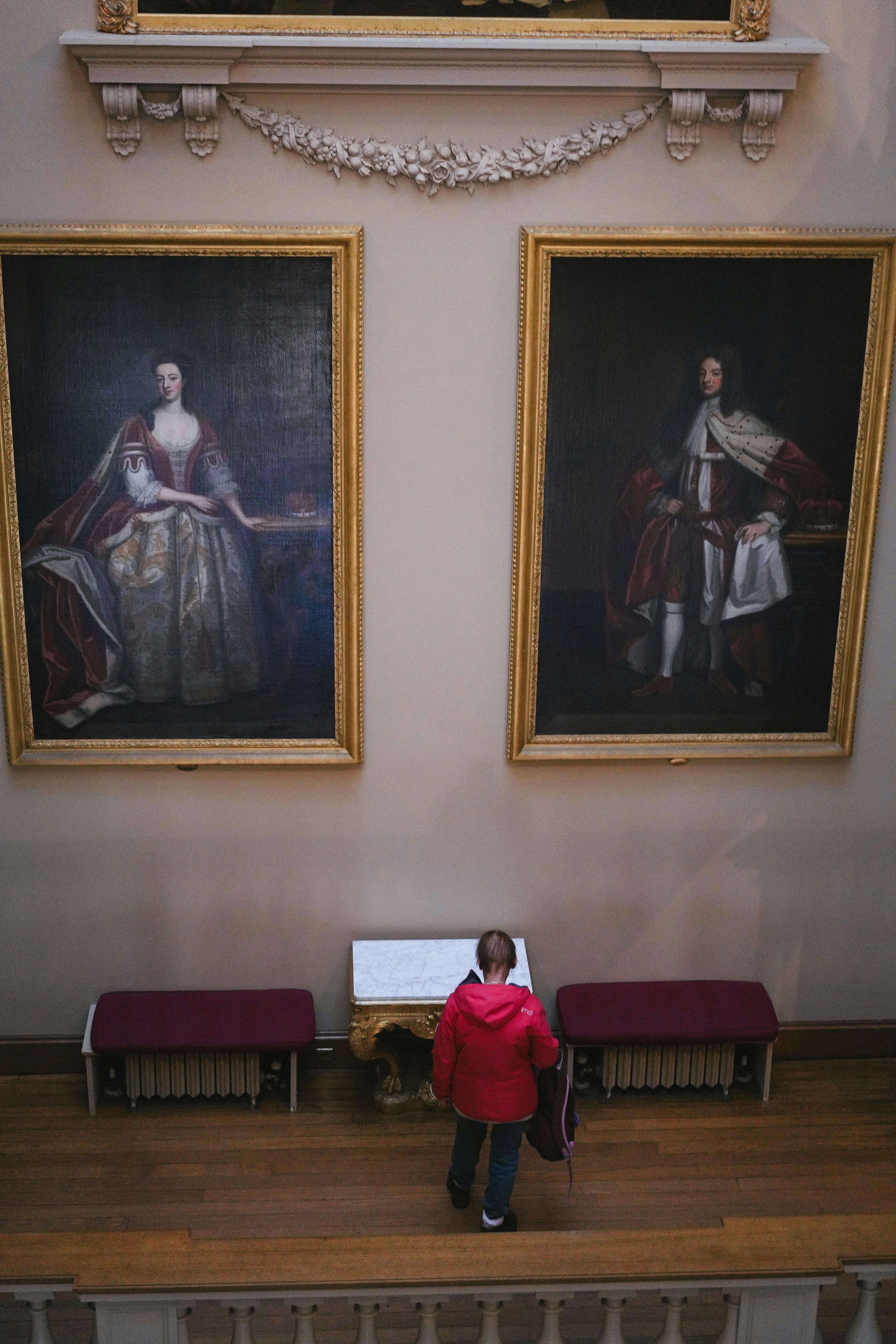 A person standing in a room with paintings on the wall