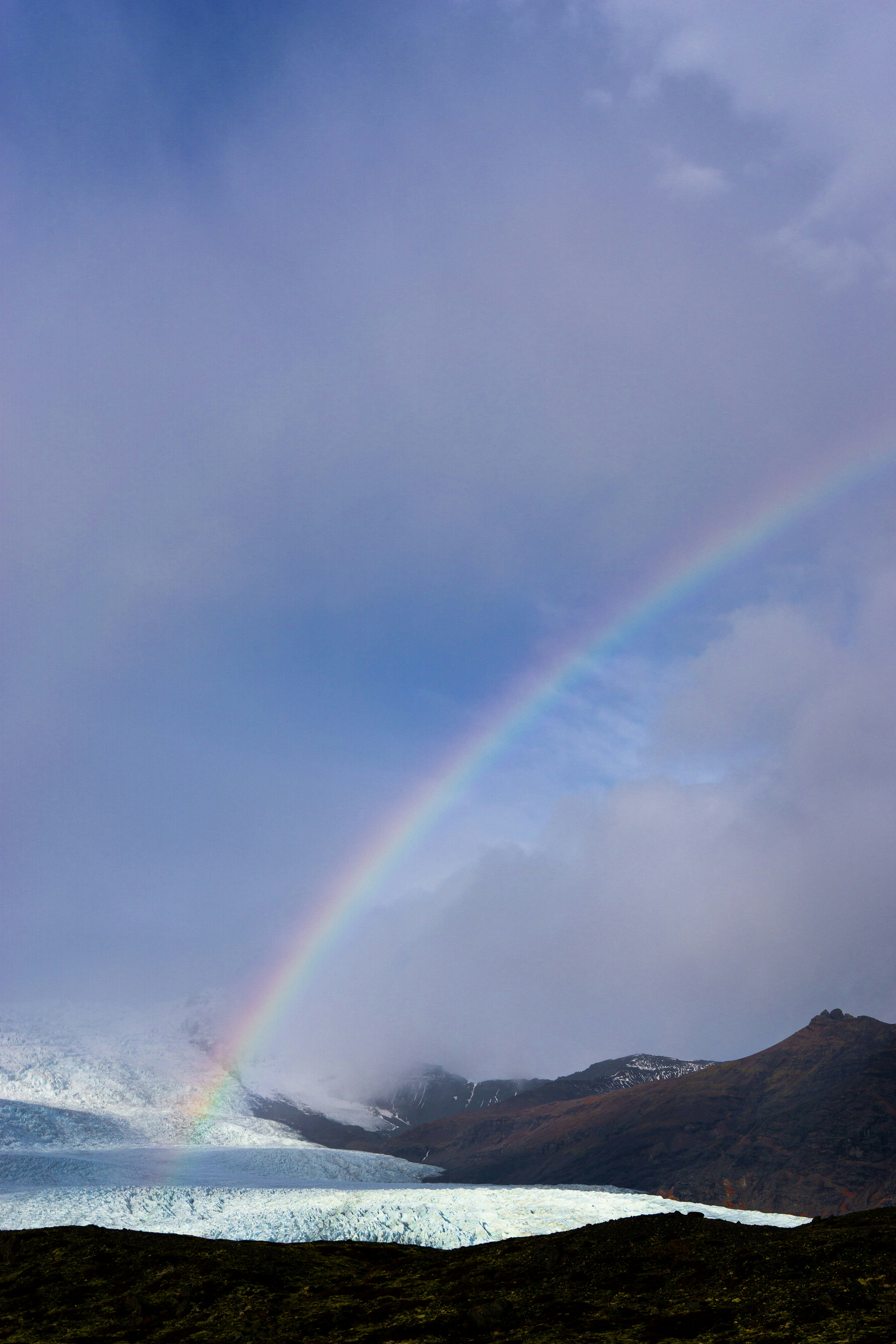 A rainbow in the sky over a body of water