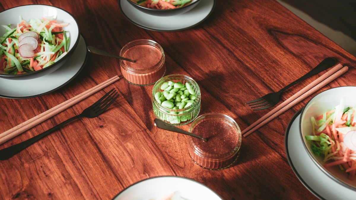 A wooden table set for a volunteer appreciation event with plates and bowls of various foods.