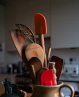 A cup filled with wooden utensils on top of a table