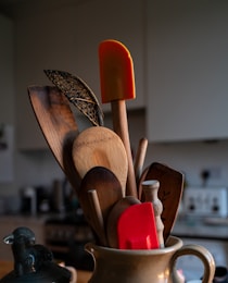 A cup filled with wooden utensils on top of a table