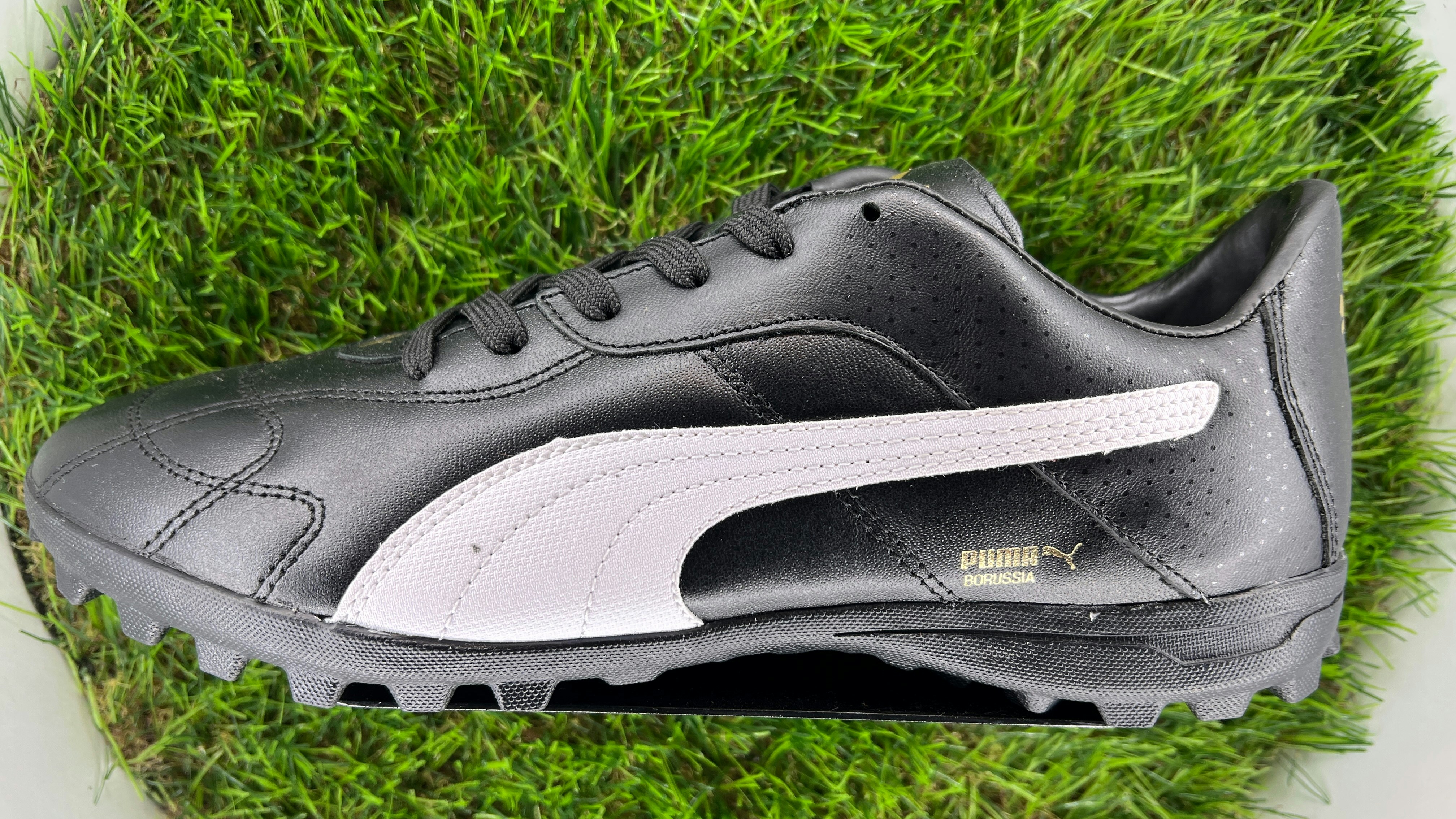 Crampons Puma noirs sur pelouse verte