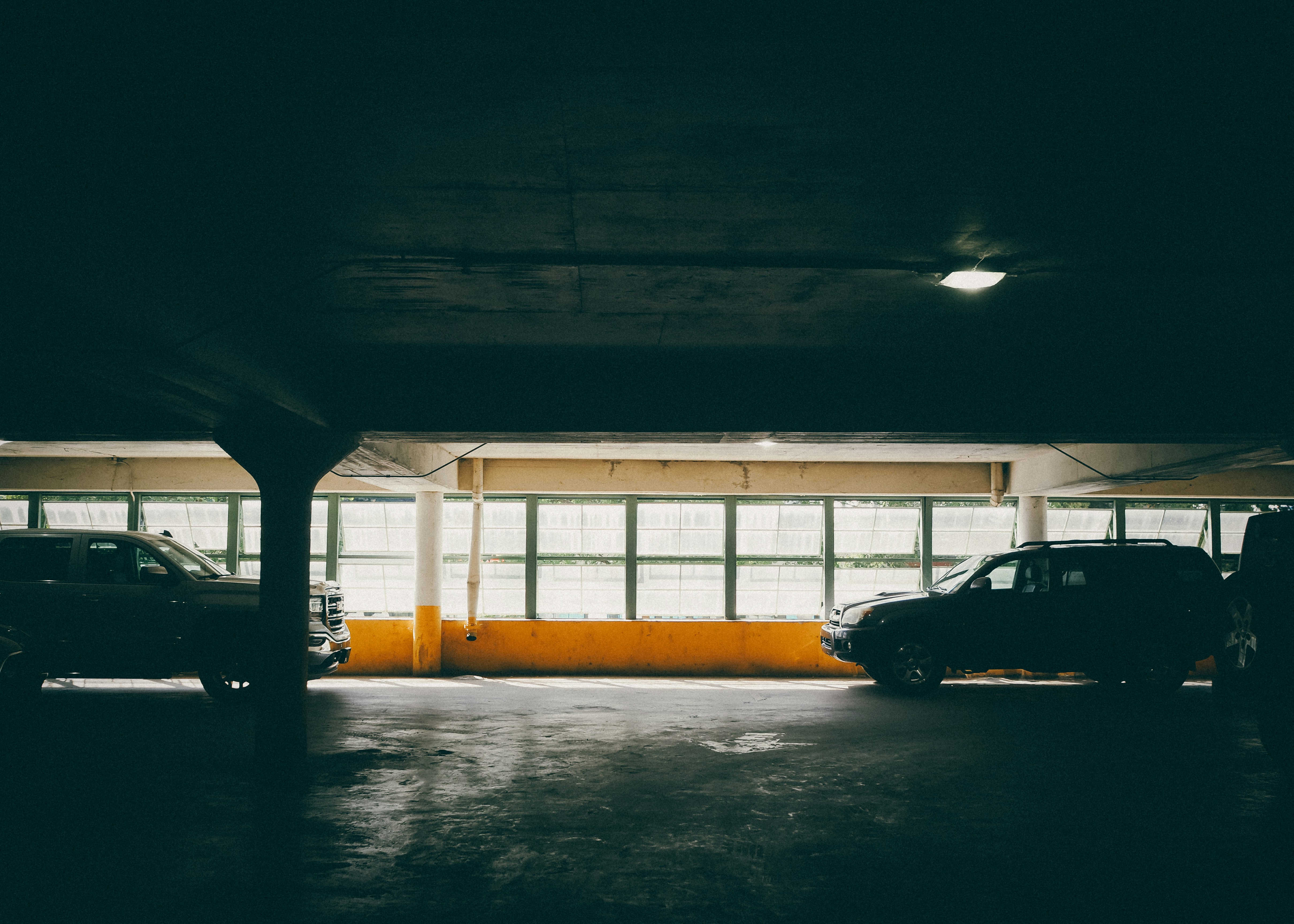 Un parking avec deux voitures garées dedans