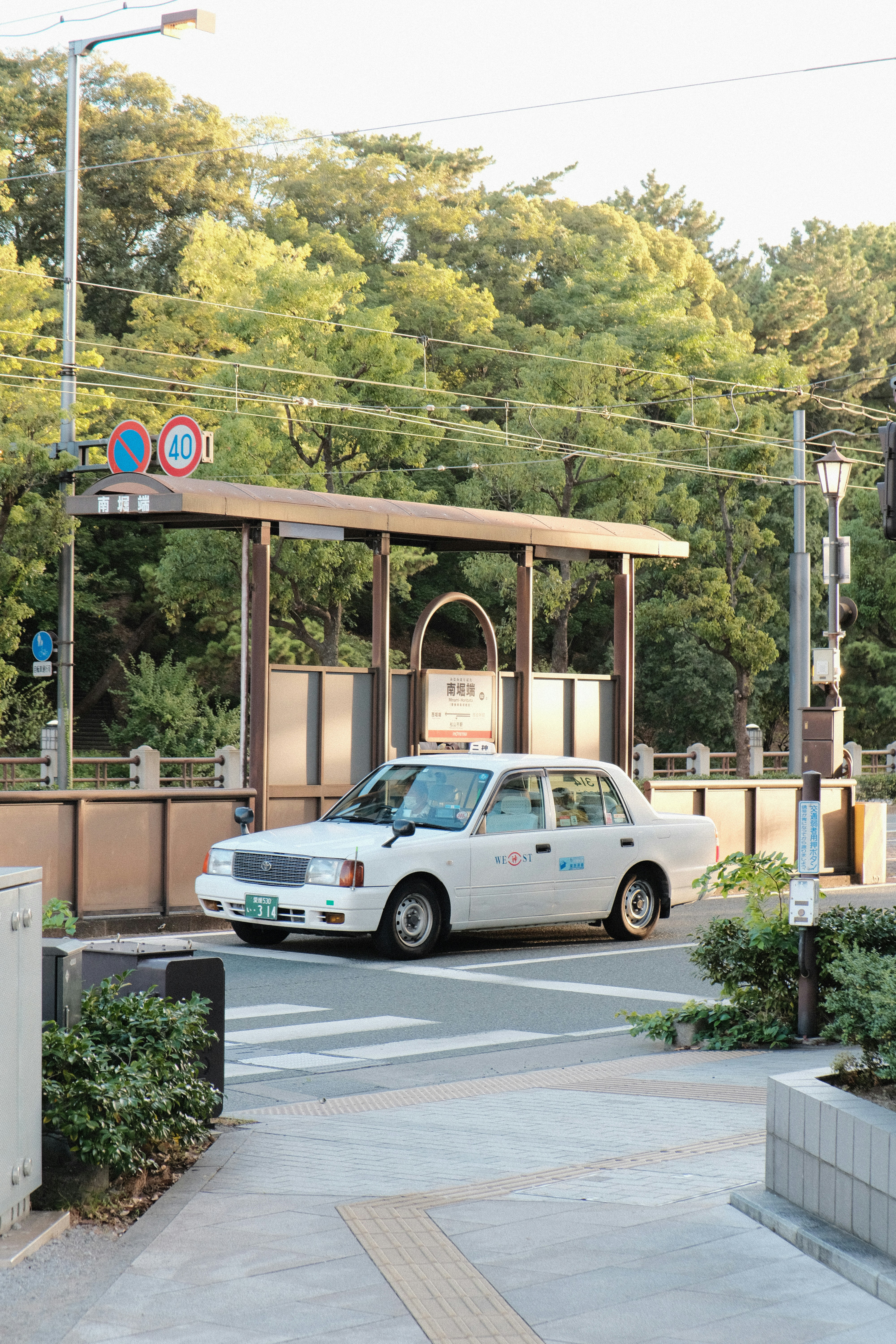 A white car driving down a street next to a traffic light