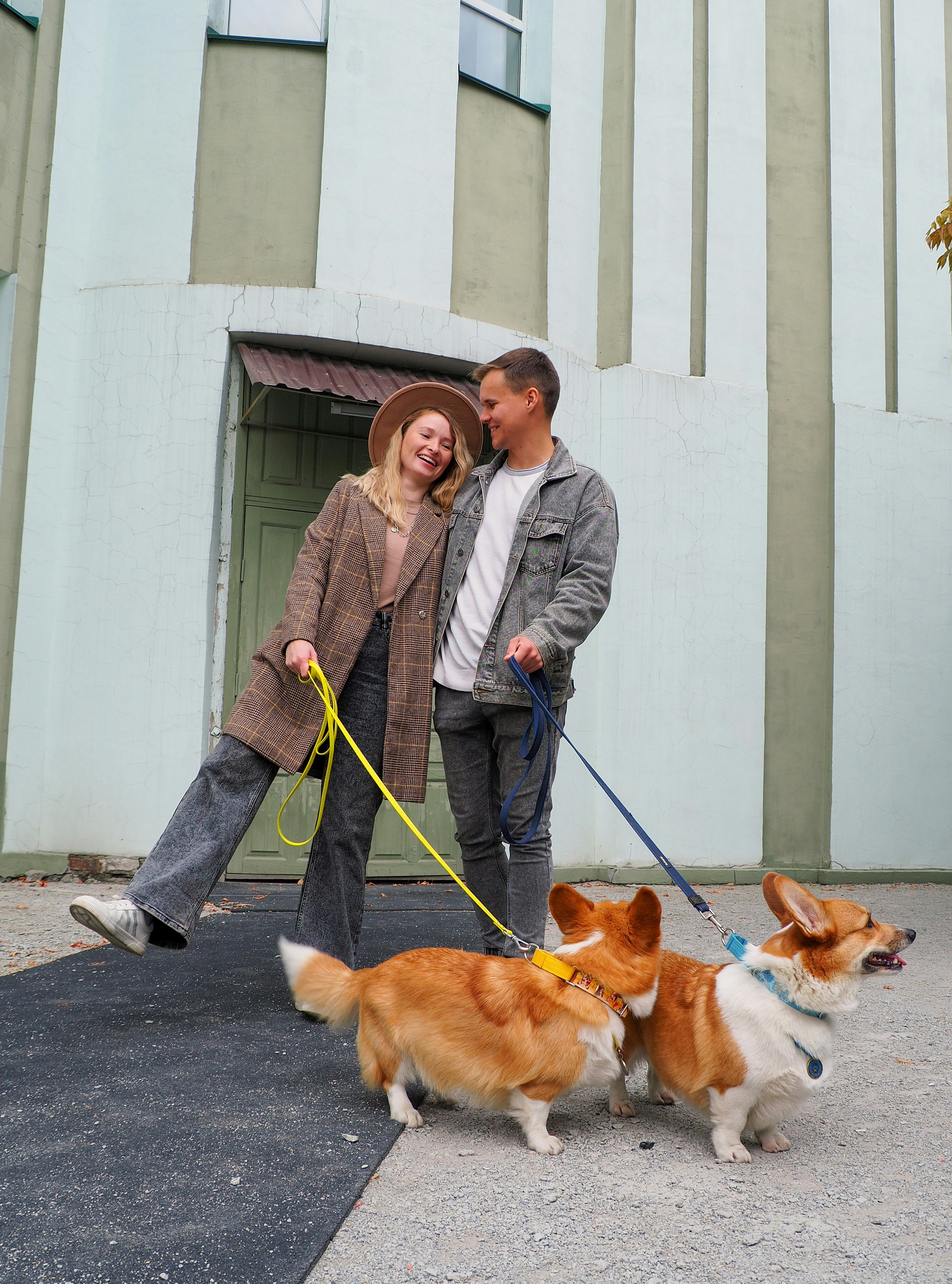 A man and woman walking two dogs on a leash