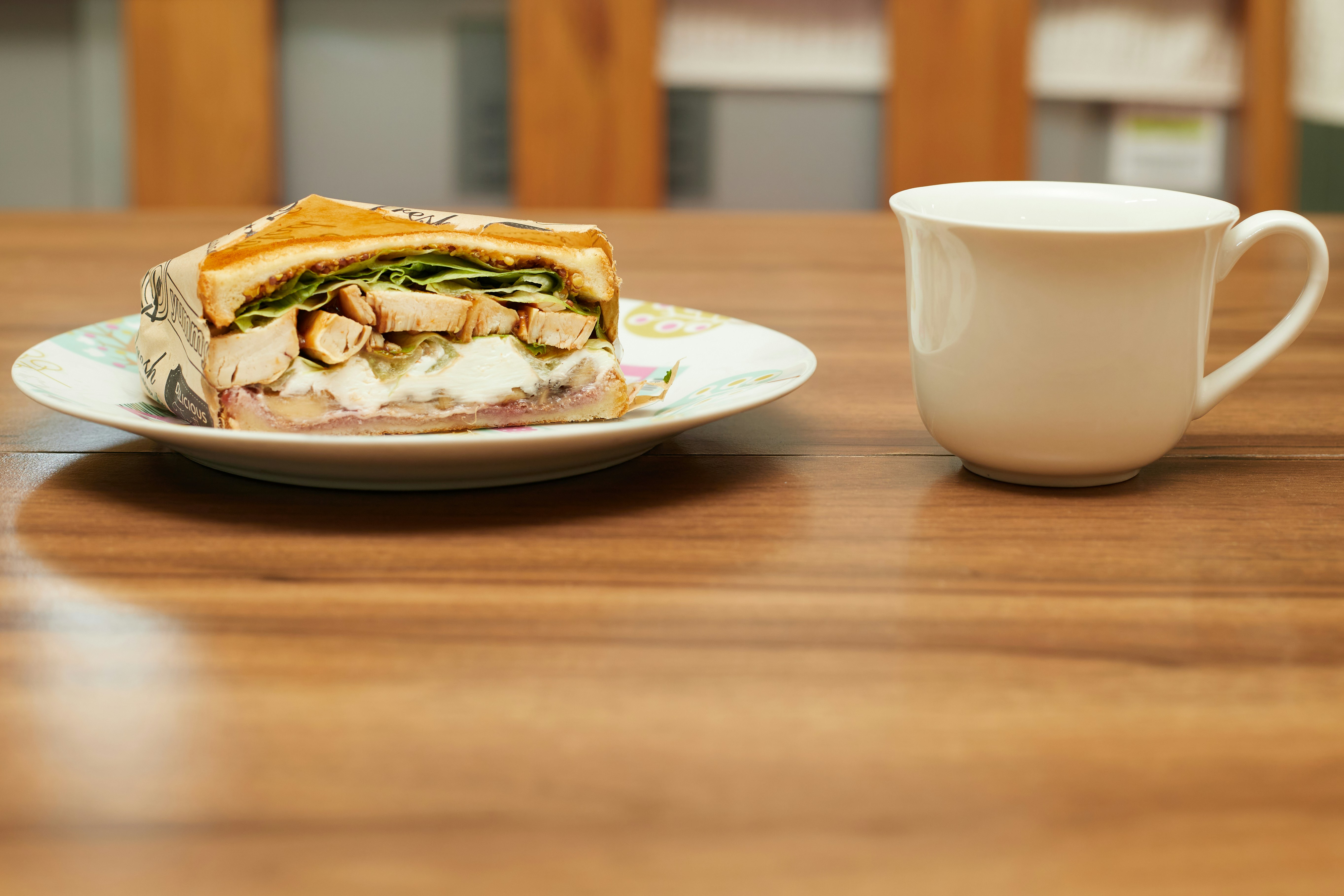 A bustling office kitchen with crumbs everywhere, a half-eaten sandwich on a plate, and suspicious eyes peeking around the corner.