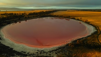 An aerial view of a red crater in the middle of a field