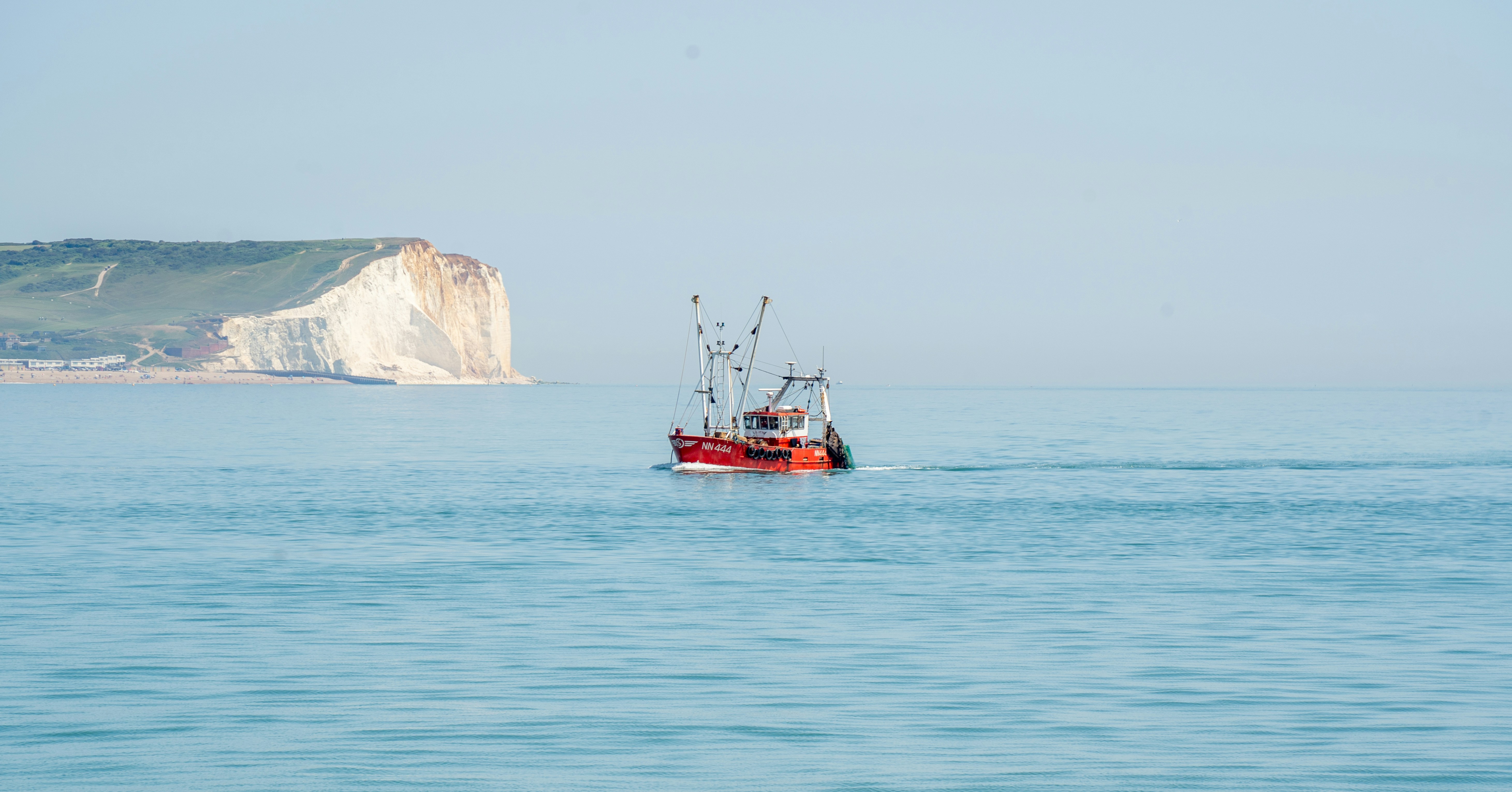 A red boat in the middle of the ocean